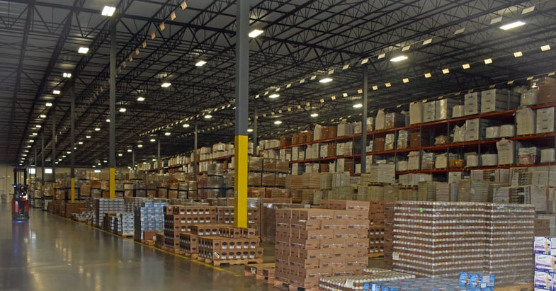 Warehouse facility showing replenished inventory in boxes on pallets filling hundreds of slots 