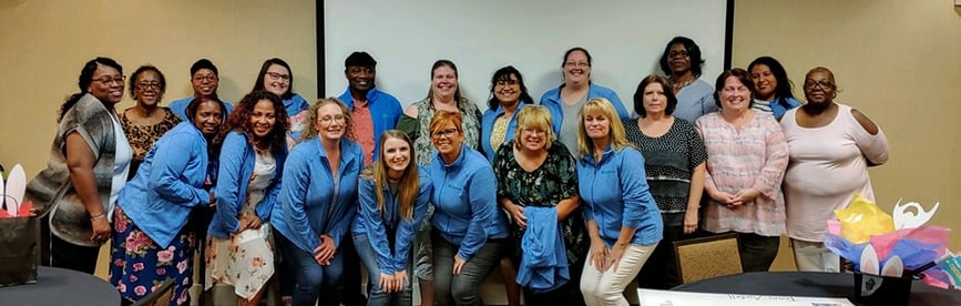 The Shippers Group Atlanta Customer Service Team poses for a group photo with their employee gifts, new TSG jackets