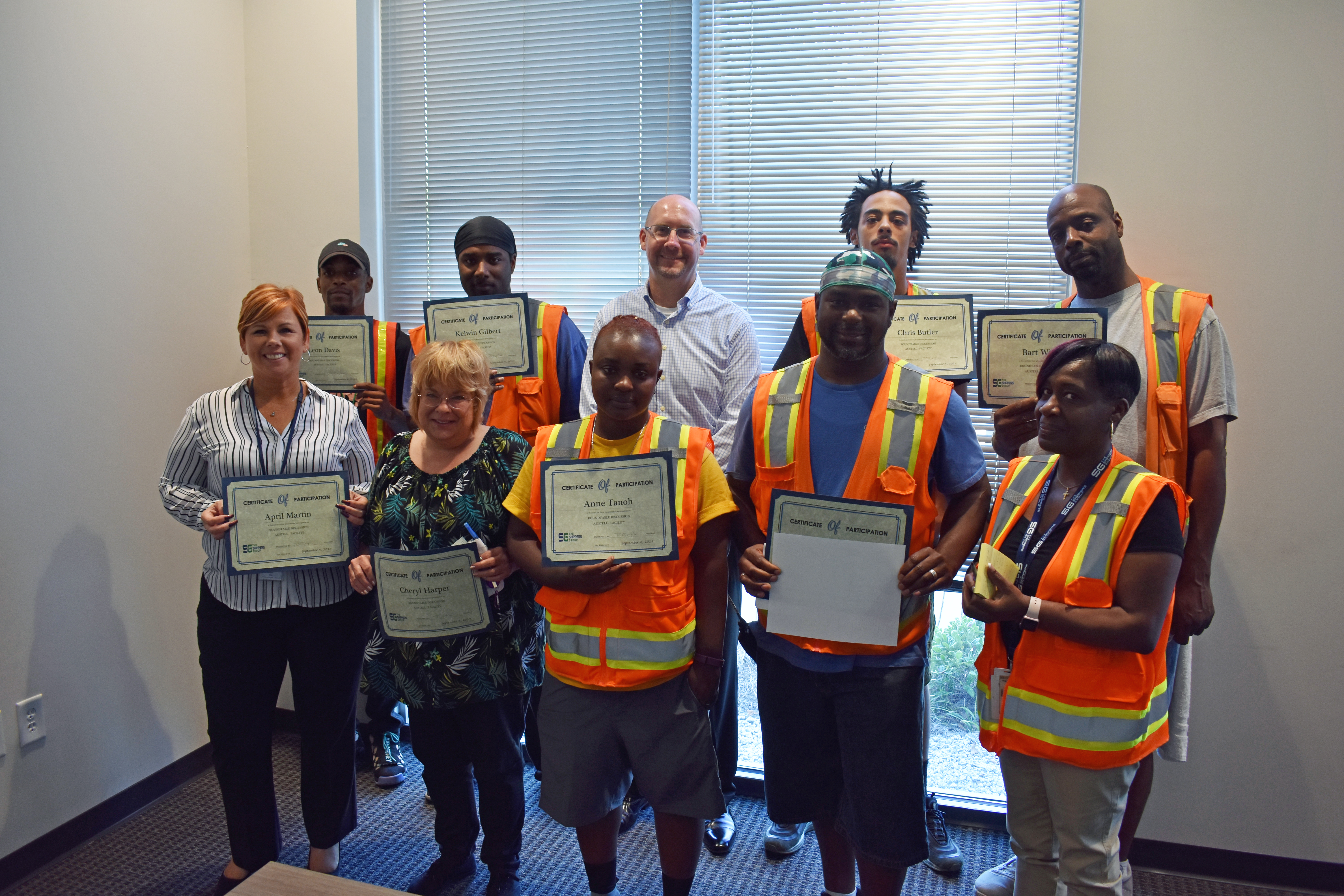 Austell Townhall August participants smiling for a group picture with their certificates of completion
