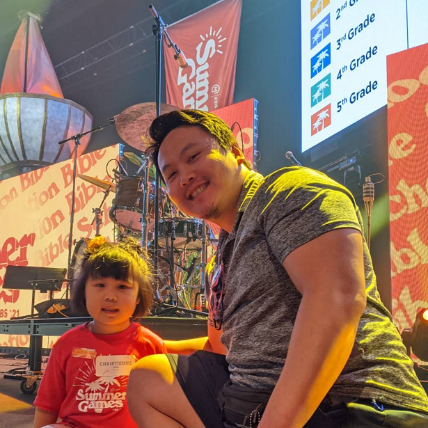 Randy Yang poses with a photo with his daughter